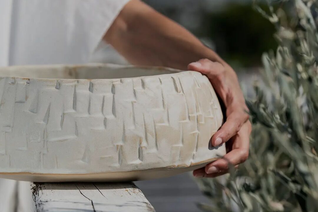 Hands holding a handmade ceramic bowl